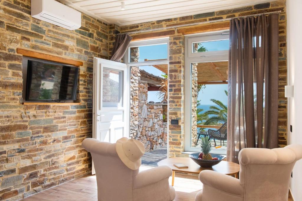 a living room with a brick wall at White & black Suites in Platis Yialos Sifnos
