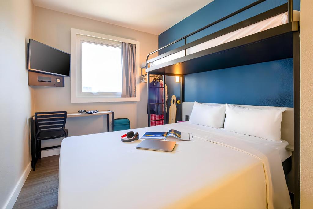 una camera d'albergo con un grande letto e una scrivania di ibis budget Sao Paulo Morumbi a San Paolo