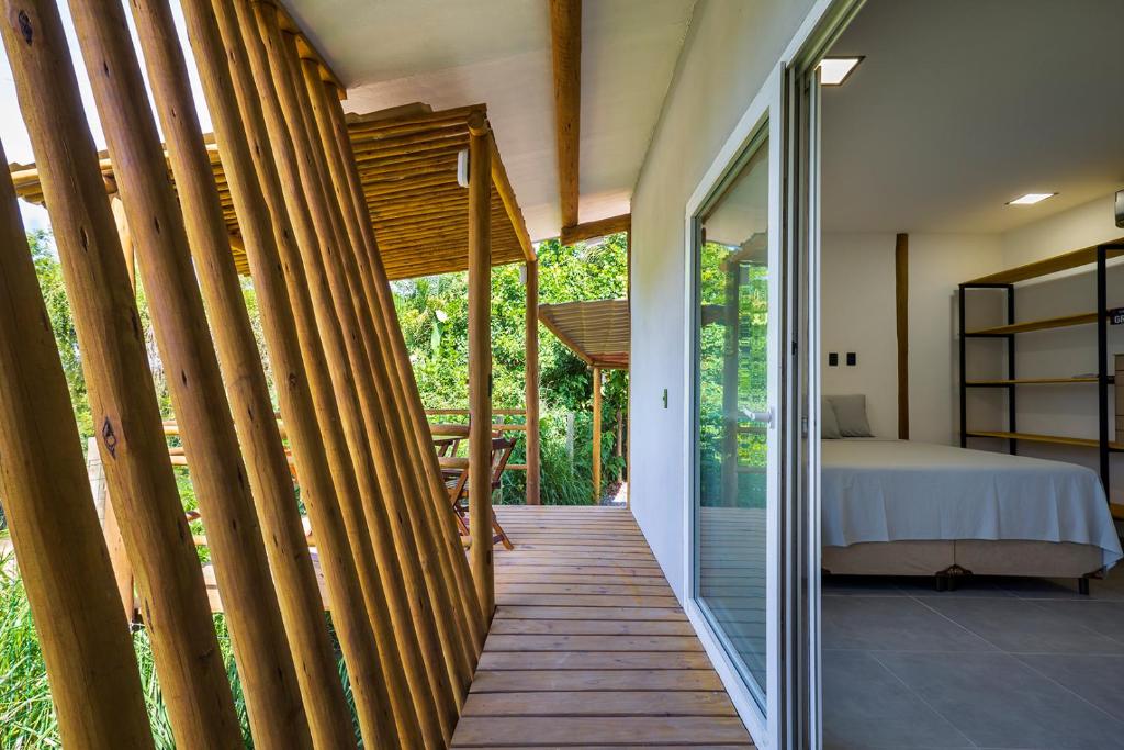 Una pasarela de madera que conduce a un dormitorio en una casa en Quartos Do Vilarejo, en Trancoso