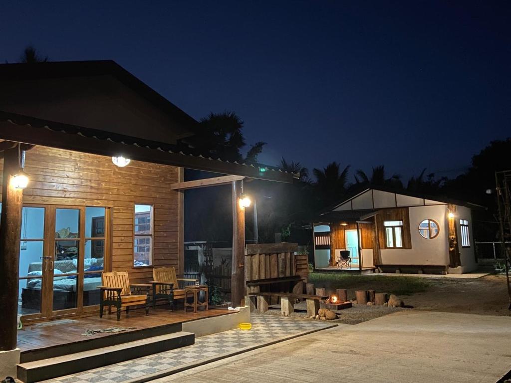 a house with a patio at night with a table and chairs at บ้านทาคายามา in Ban Phae Khwang