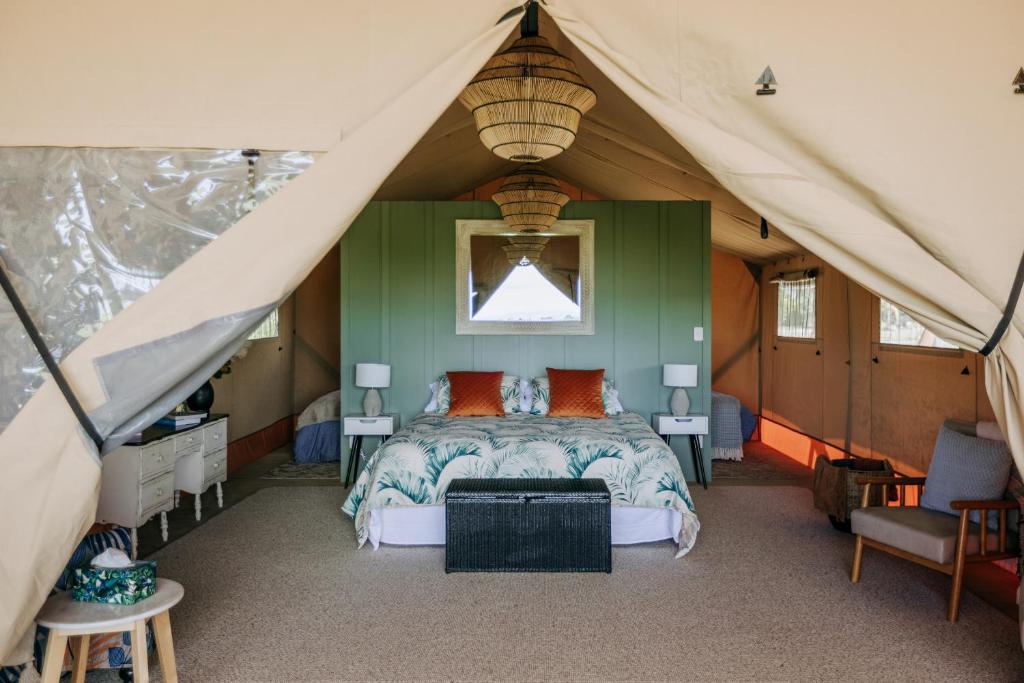 a bedroom with a bed in a tent at Villas & Vines Glamping in Hastings