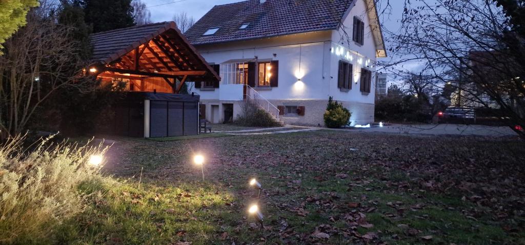 a house with lights in the yard at night at AOG PRESTIGE ESPLANADE HOME colmar in Muntzenheim