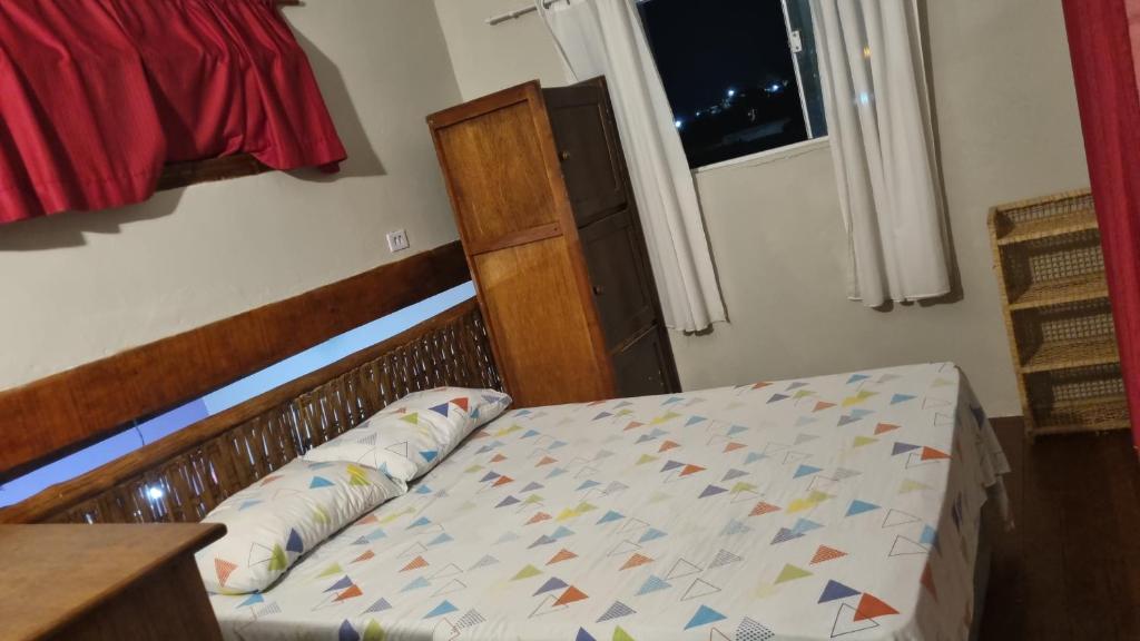 a bedroom with a bed with a wooden head board at Casa Cláudio Rambo in Ilhabela