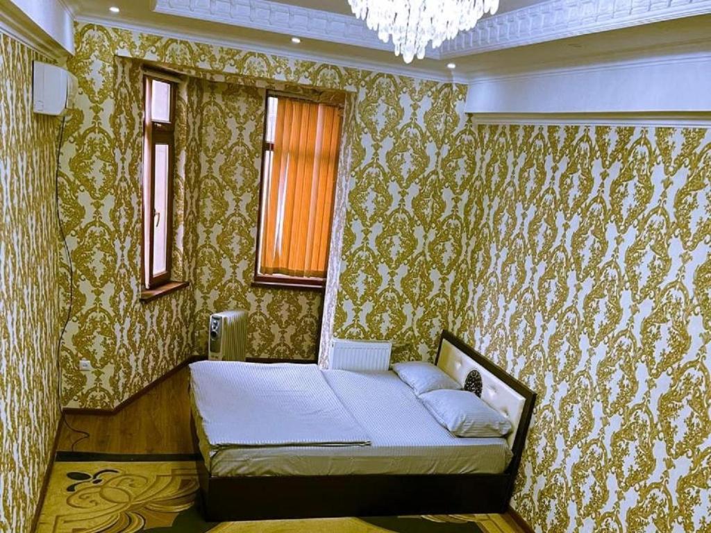 a bedroom with a bed in a room with wallpaper at one-room apartment in Dushanbe in Dushanbe