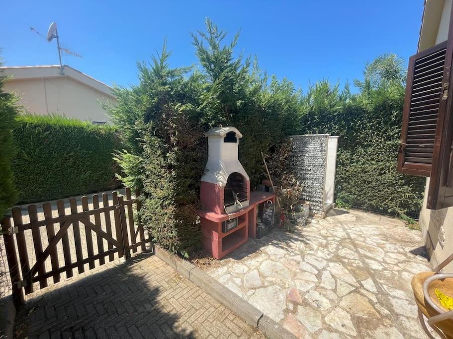 a garden with a large vase sitting next to a fence at Villa Hidra near Cefalù in Buonfornello