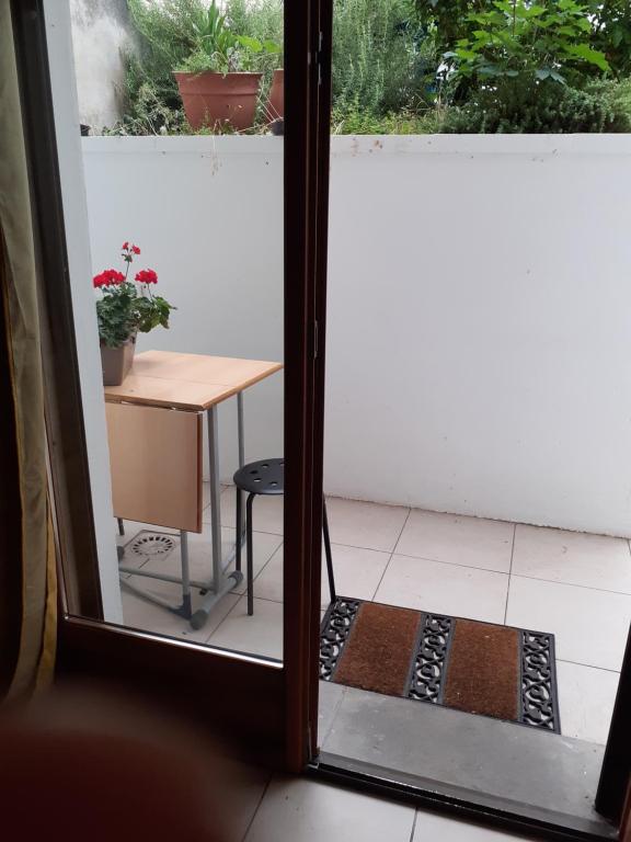 a door leading to a patio with a table and a table at l'appartement idéal pour visiter Paris in Champigny-sur-Marne