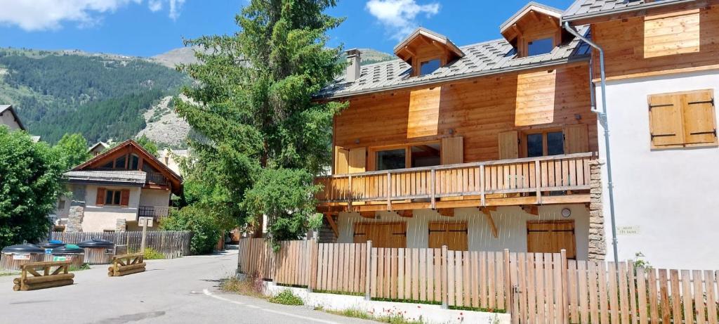 a wooden house with a fence in front of it at Magnifique duplex au pied des pistes, rénové dans maison de pays in Le Monêtier-les-Bains