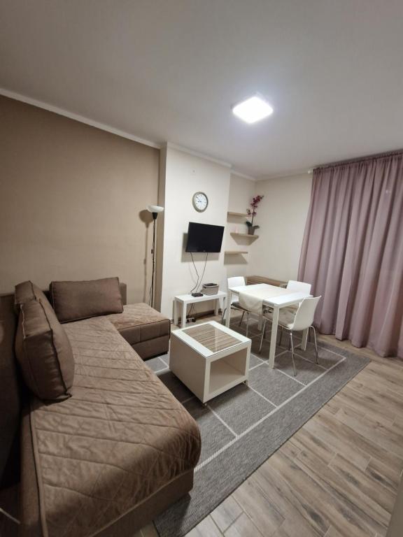 un soggiorno con divano e tavolo di Apartman Dixy a Pirot