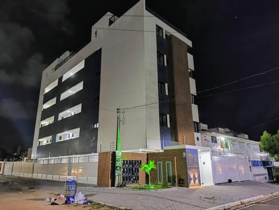 a tall white building at night with at Apartamento Completo Praia do Poço - Cabedelo - PB in Cabedelo