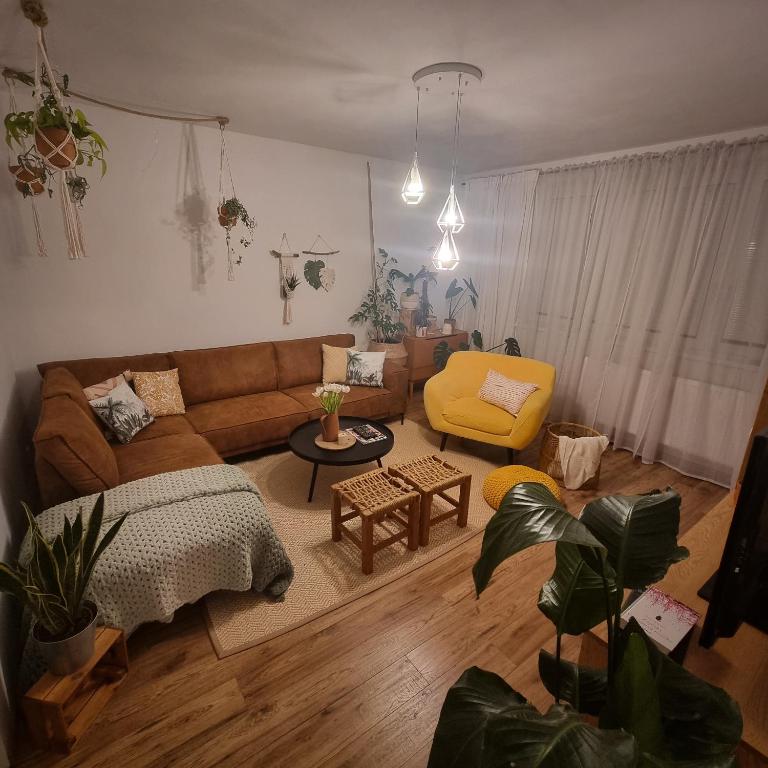 sala de estar con sofá marrón y silla amarilla en Slnečná oáza pokoja, en Partizánske