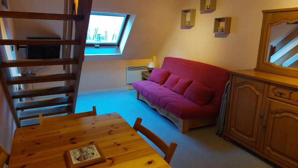 un salon avec un canapé rouge et une table dans l'établissement Appartement au pied de la Crémaillère Express, à Luchon