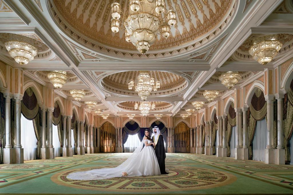 a bride and groom posing in a ballroom at InterContinental Abu Dhabi by IHG in Abu Dhabi