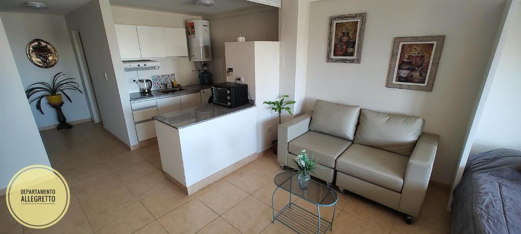 a small living room with a couch and a kitchen at Departamento Allegretto Monoambiente in San Luis