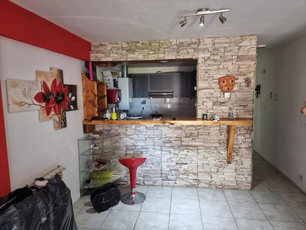 a kitchen with a counter and a brick wall at Depto Mitre Centro in San Carlos de Bariloche