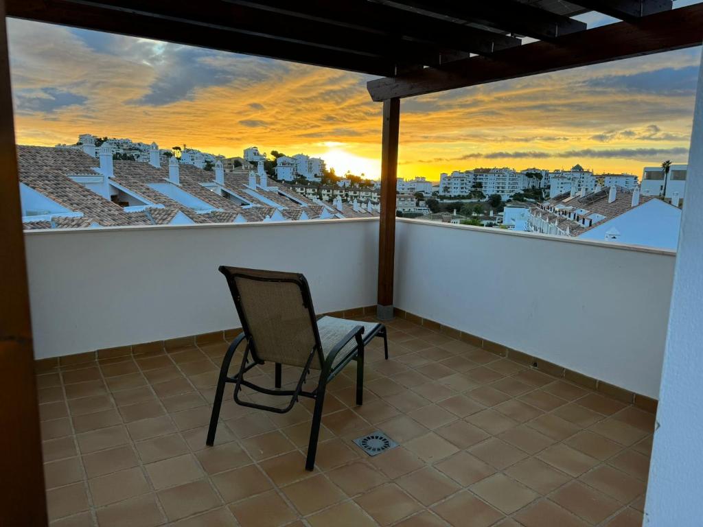 una silla en el balcón con vistas a la ciudad en Casa Topacio Luxury Villa, 3 bedrooms sleeps 8, en Mijas