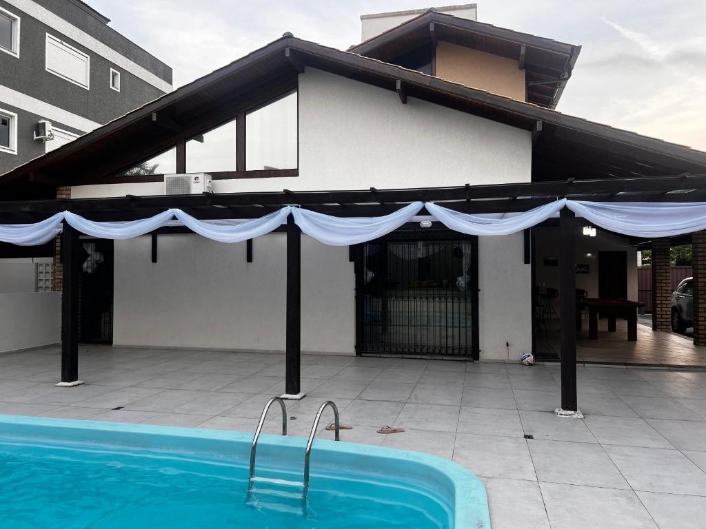 Casa con piscina y sombrilla azul en Casa com piscina praia dos Ingleses, en Florianópolis