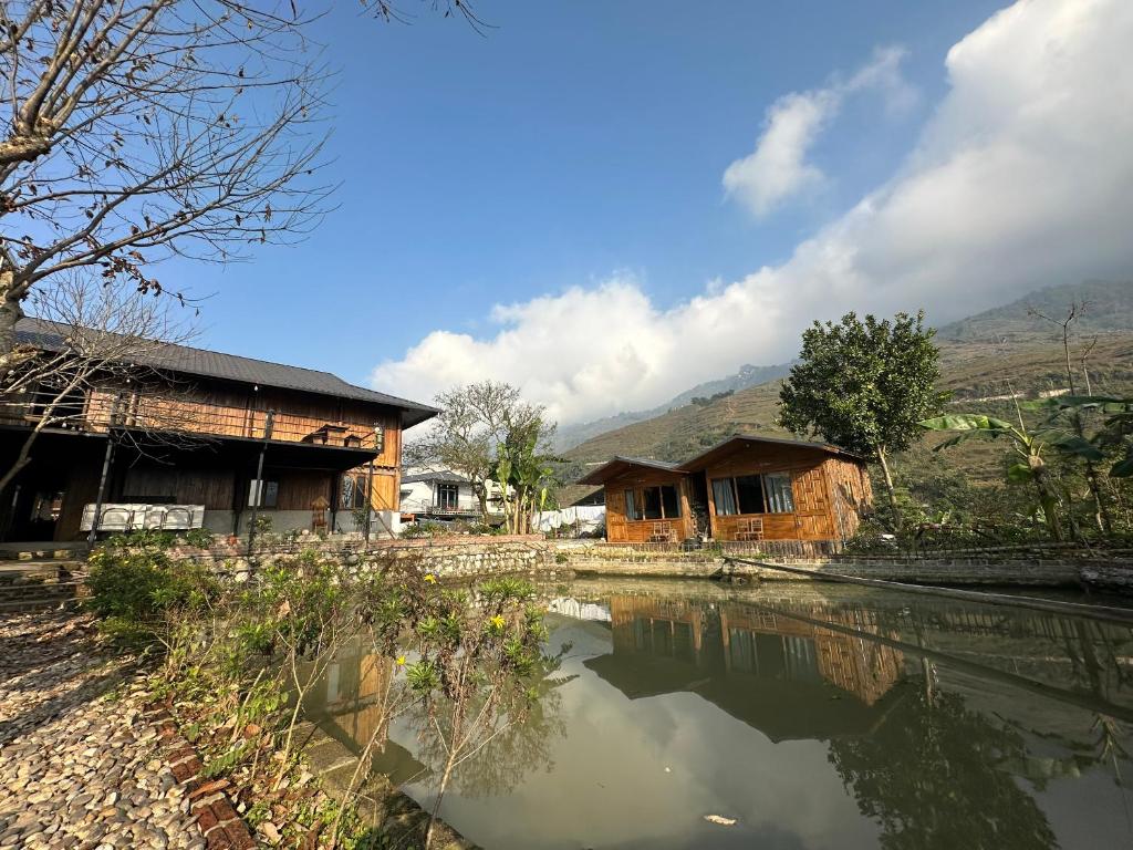 a house next to a body of water at Little Ta Van Homestay in Sa Pa