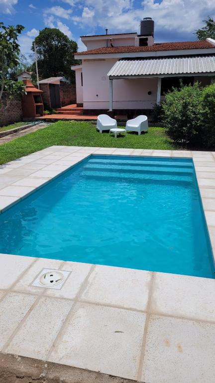 una piscina azul frente a una casa en Casa Villa del Dique en Villa del Dique