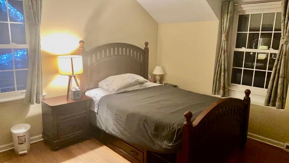 a bedroom with a bed and a lamp and two windows at B1 A private room in Naperville downtown with desk and Wi-Fi near everything in Naperville