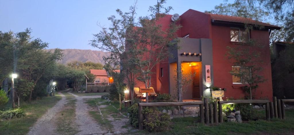 una casa roja con un camino de tierra delante de ella en Casitas Volver a Nacer en Carpintería