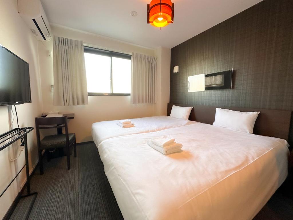 a hotel room with a large bed and a television at Ostay Kyoto west hotel APT in Kyoto