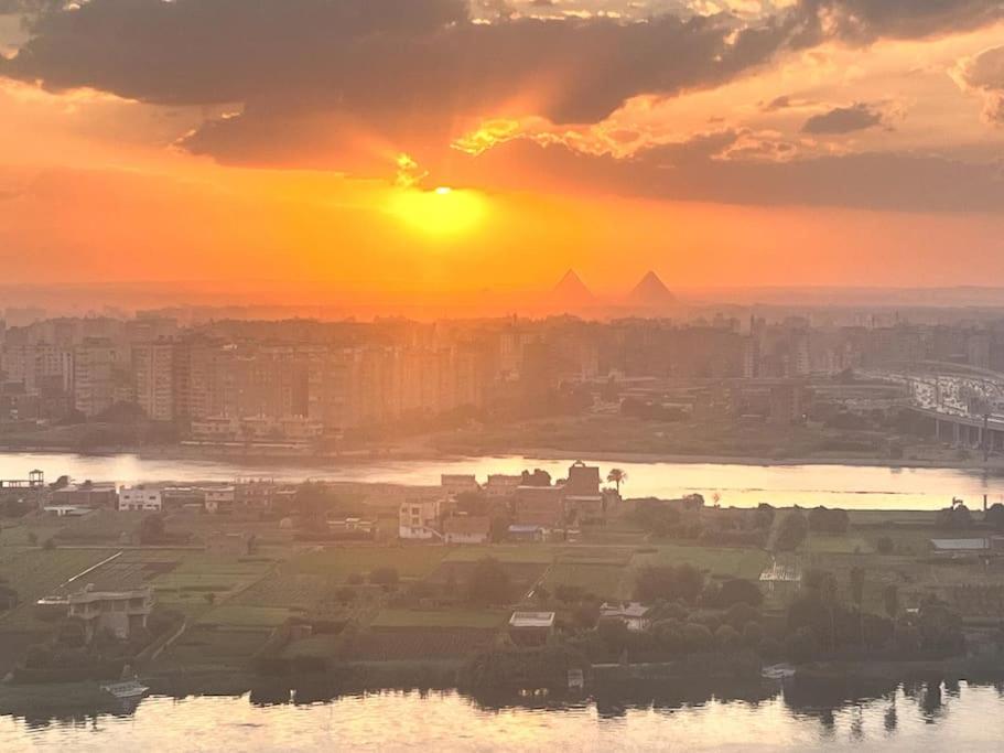 - une vue sur la ville et le coucher du soleil dans l'établissement Maadi Nile and pyramids view, au Caire