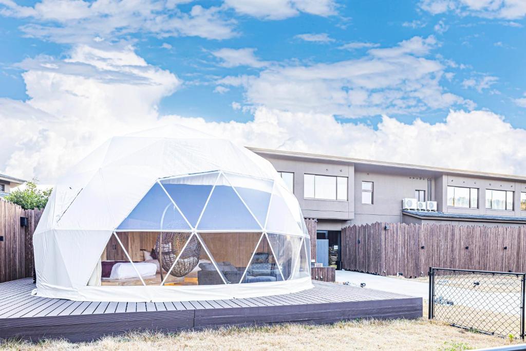 a white tent in front of a house at glampark ACONCAGUA RESORTS in Minami Aso