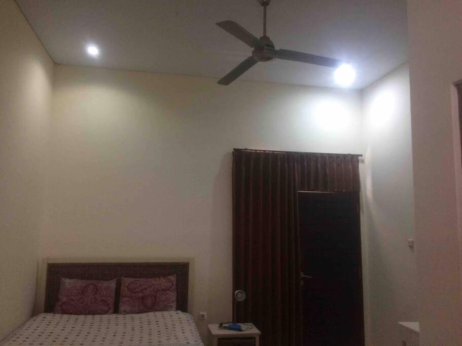 a bedroom with a ceiling fan and a bed at simple apartment 2 in Seminyak