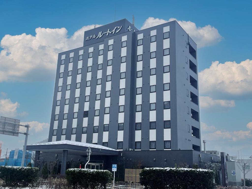 Un edificio alto con un cartel encima. en Hotel Route-Inn Tendo, en Tendō