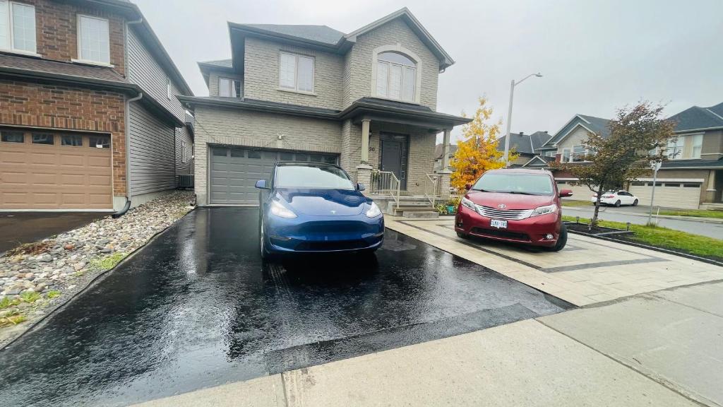 dois carros estacionados numa entrada em frente a uma casa em SABAA em Ottawa