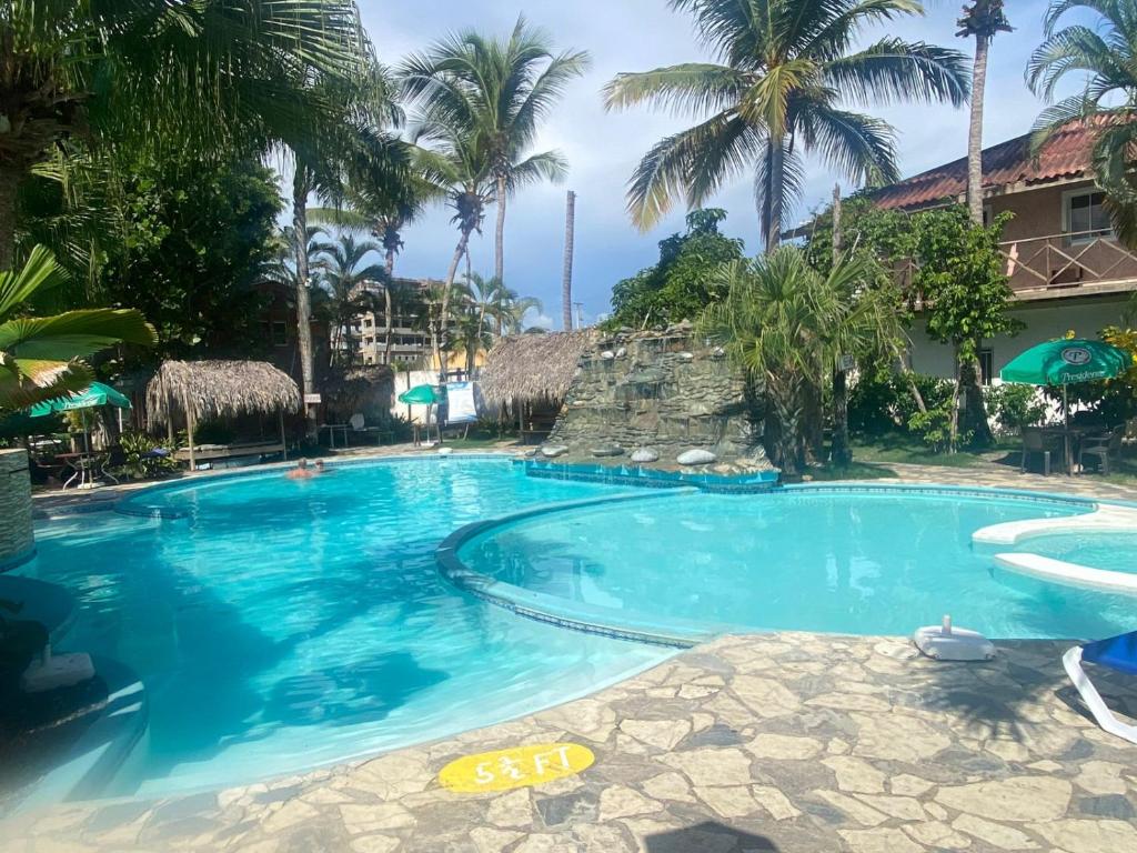 una gran piscina con palmeras en un complejo en Plaza Real Resort en Juan Dolio