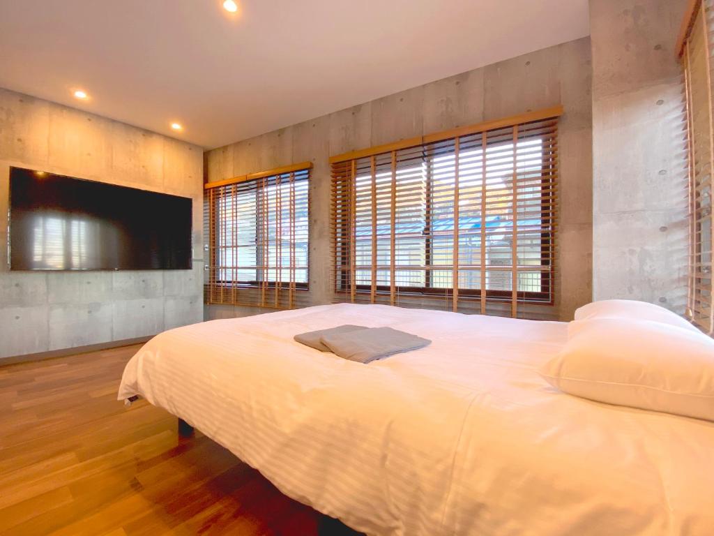 um quarto com uma cama grande e uma televisão de ecrã plano em さくらや旅館 em Mongawa