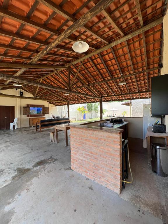 an empty room with a brick counter and a table at Espaço Ranchão com Piscina em São Pedro - SP in São Pedro