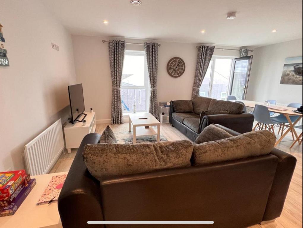 a living room with a couch and a table at Royal Atlantic View Apartment in Portrush