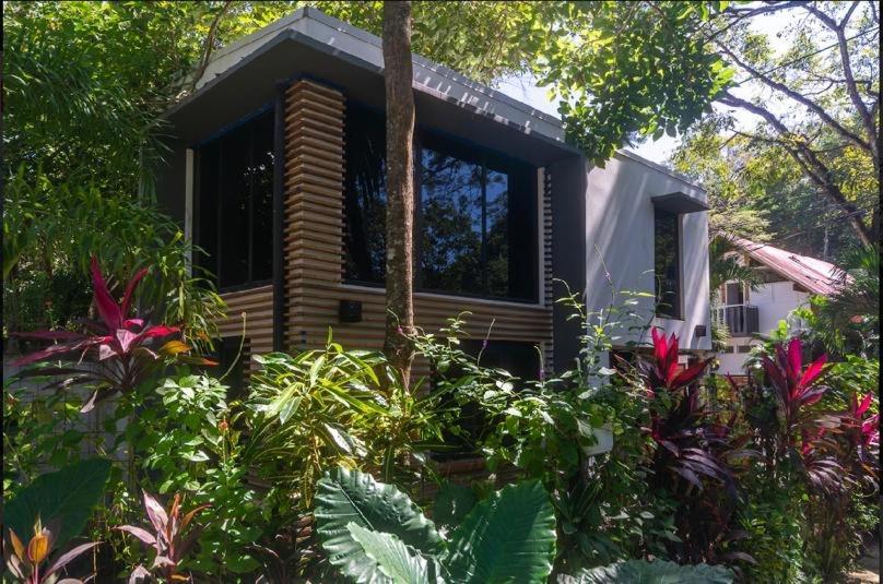 a small house surrounded by trees and plants at Condo VNV walking to Playa Guiones in Nosara