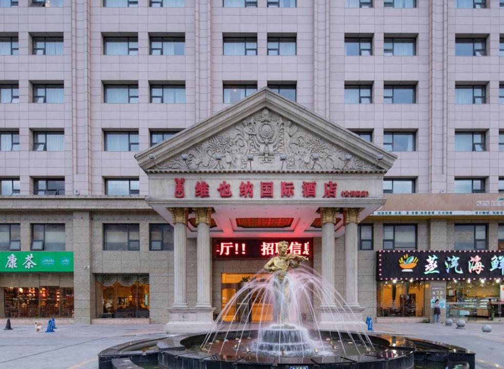 a fountain in front of a large building at Vienna International Hotel - Shanghai World Expo Garden in Shanghai