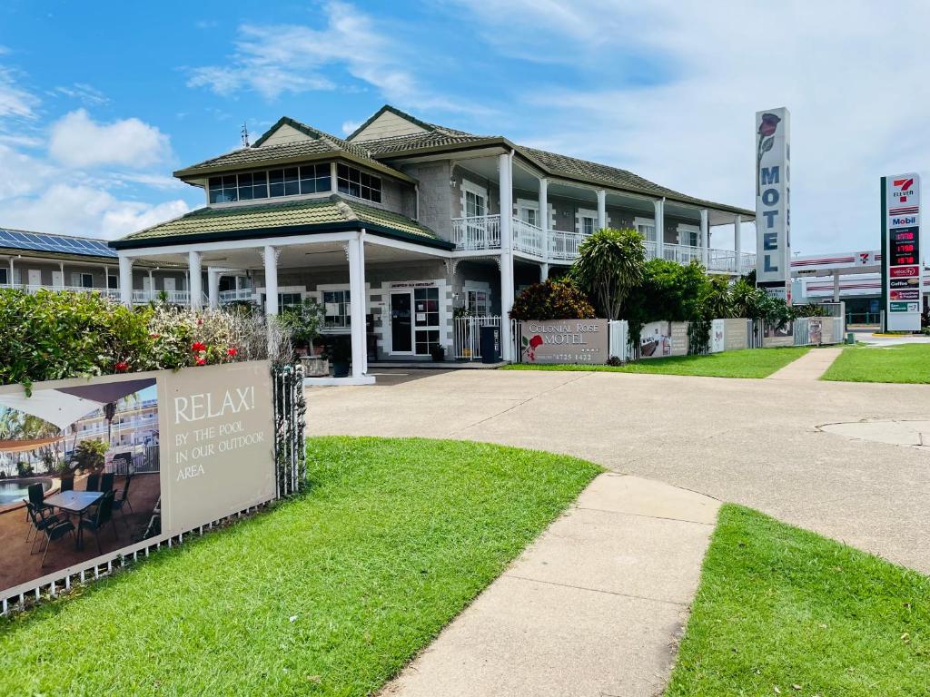 une maison avec un panneau devant elle dans l'établissement Colonial Rose Motel, à Townsville