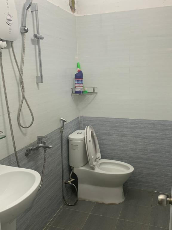 La salle de bains est pourvue de toilettes blanches et d'un lavabo. dans l'établissement The Vinyl Homestay, à Hô-Chi-Minh-Ville