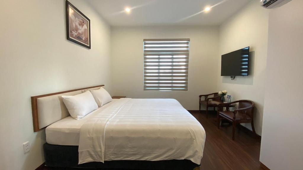 1 dormitorio con 1 cama grande y TV en Yên Tử Boutique Hotel, 
