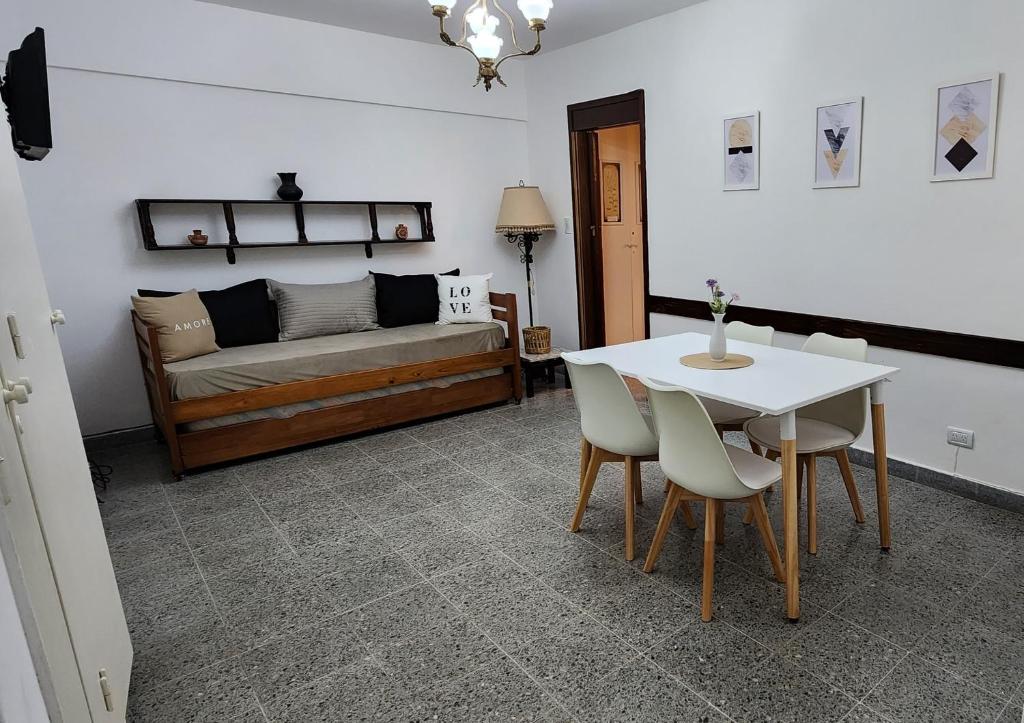 Depto de 2 ambientes zona Guemes (2) في مار ديل بلاتا: غرفة معيشة مع سرير وطاولة وكراسي