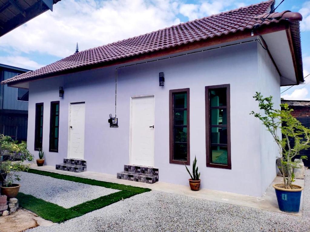 a white home with a red roof at Roomstay Kak Ton in Kuala Terengganu
