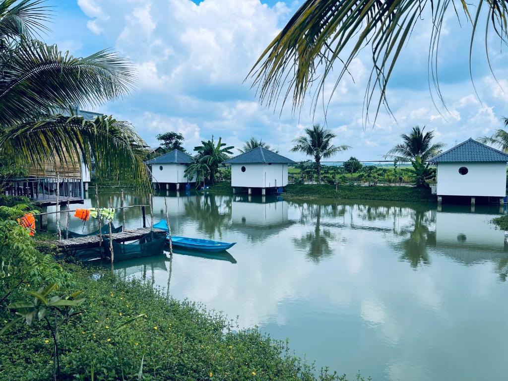 un grupo de casas y barcos en un río en LUA Farmstay en Ba Ria