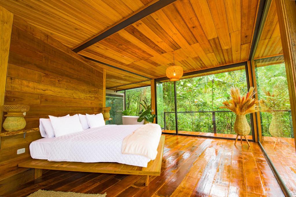Mera的住宿－Cedro Amazon Lodge，一间带一张大床的卧室,位于带木墙的房间
