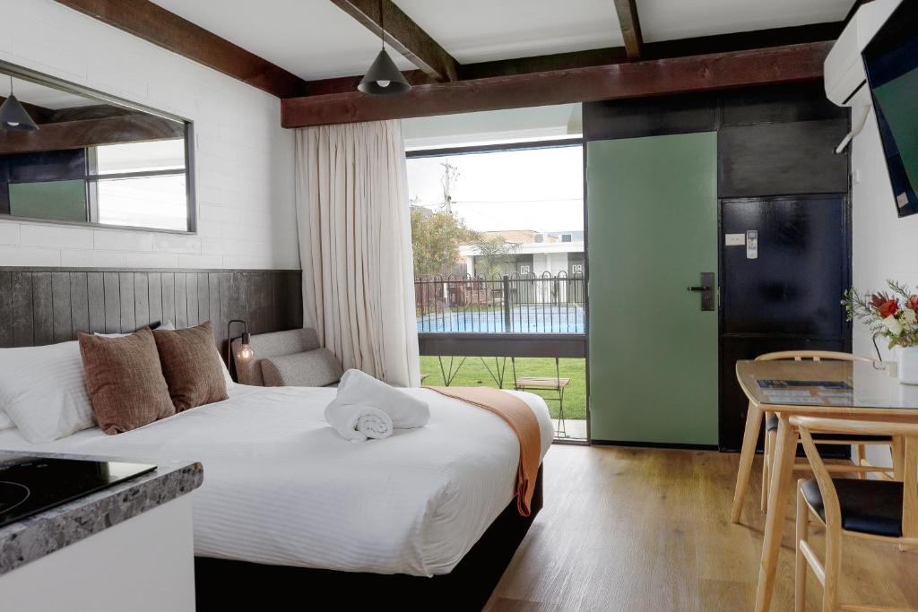 a bedroom with a bed and a kitchen with a table at m hotel in Sale