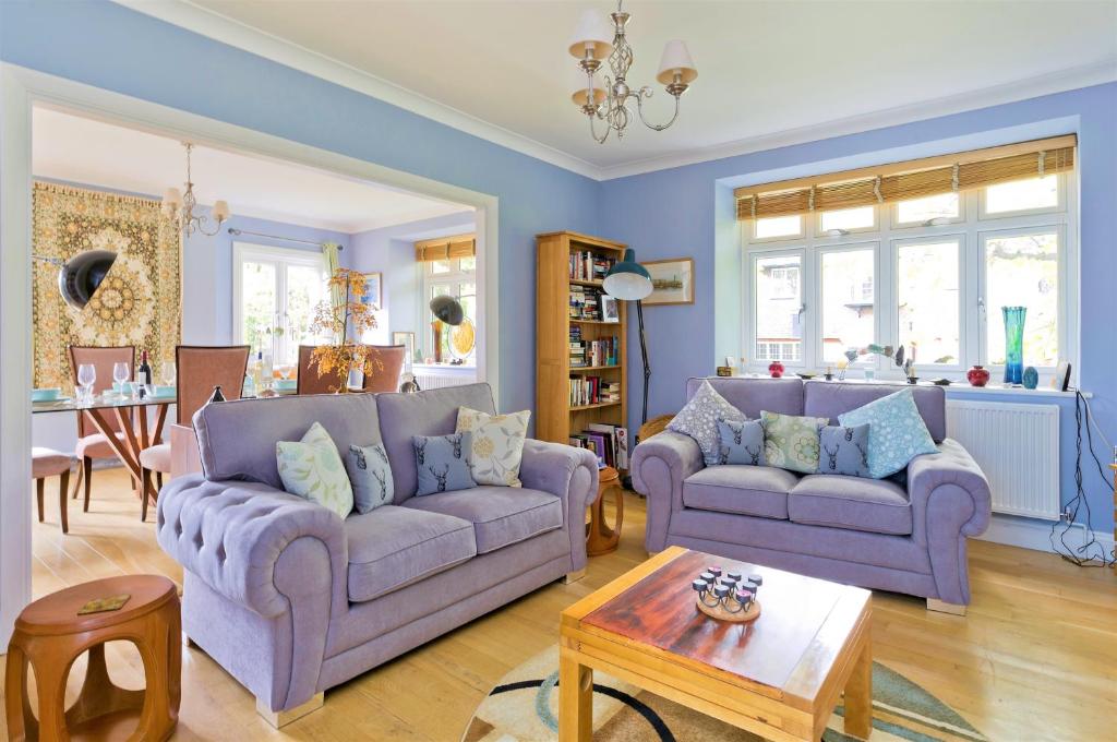 a living room with two purple couches and a table at Delightful apartment in prime location near Hampstead Heath by UnderTheDoormat in London