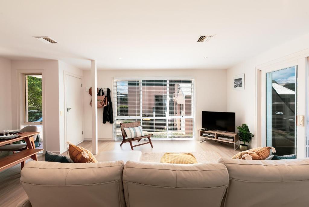a living room with a couch and a tv at Lookout 100m to the Ocean and Pet-Friendly in Ocean Grove