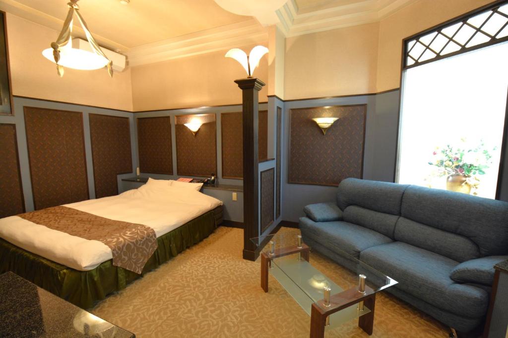 Habitación de hotel con cama y sofá en 水戸PARCO, en Mito