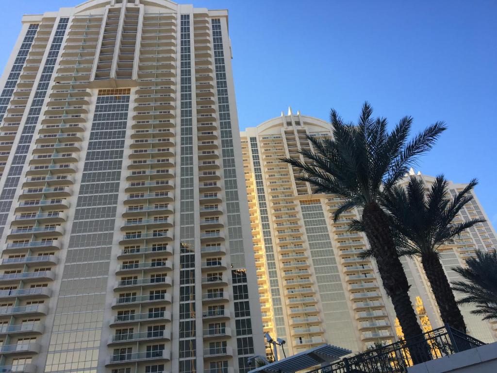 a tall building with a palm tree in front of it at MGM Signature Condo Hotel by Owner - No Resort Fee !! in Las Vegas
