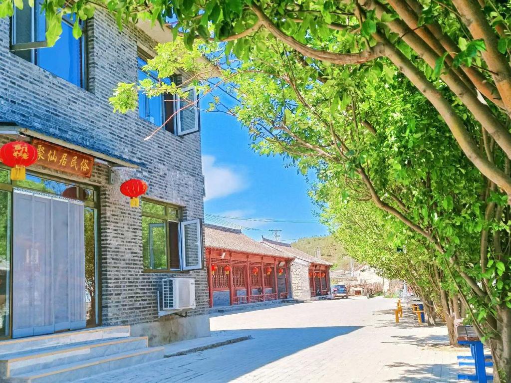 a street in an asian city with red buildings at Gubeikou Great Wall Juxian Residents' Lodging in Miyun