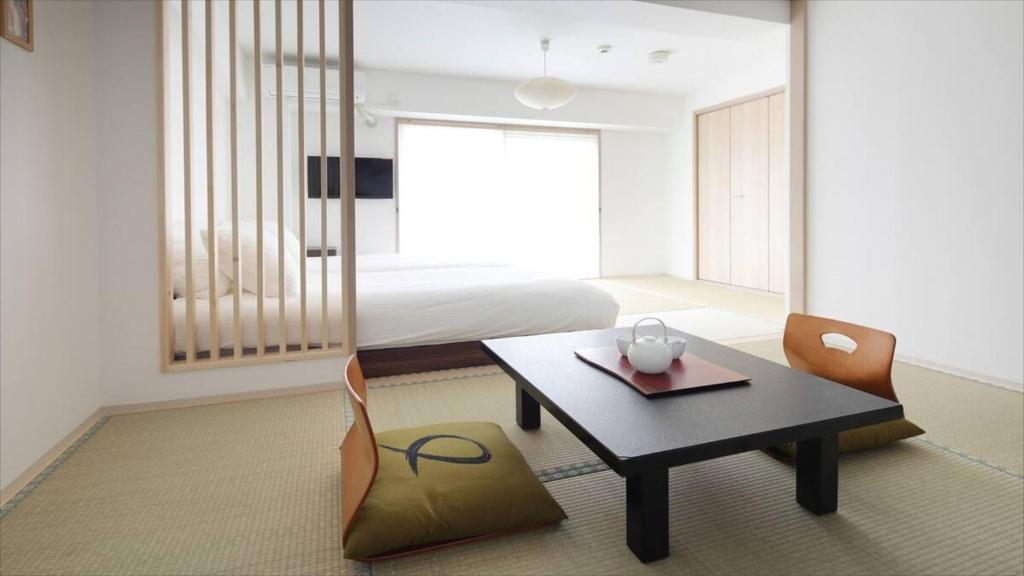 a room with a table and chairs and a bed at Kyoto - Hotel / Vacation STAY 73651 in Kyoto